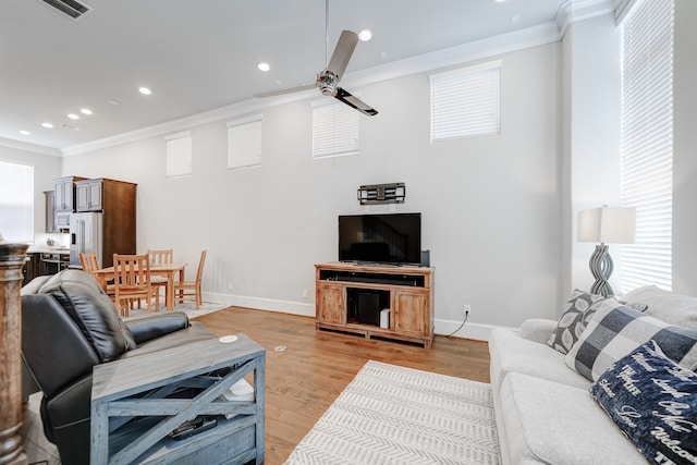 living room with ceiling fan, ornamental molding, and light hardwood / wood-style floors