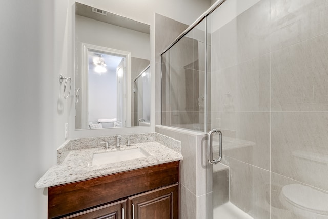 bathroom featuring walk in shower, vanity, and toilet