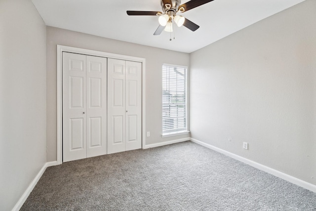 unfurnished bedroom featuring multiple windows, carpet flooring, a closet, and ceiling fan