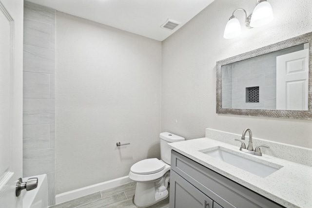 bathroom with vanity, toilet, and walk in shower