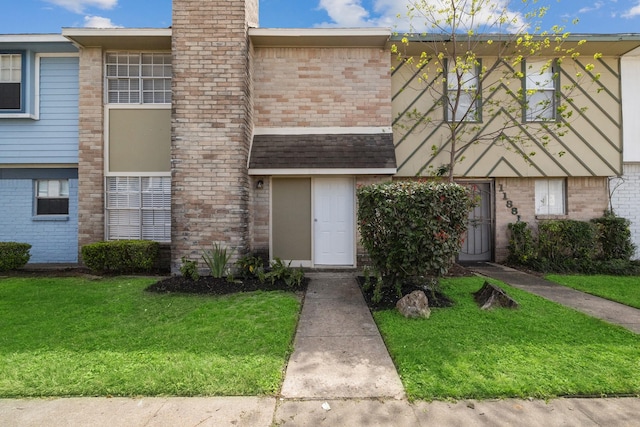 townhome / multi-family property with a front yard