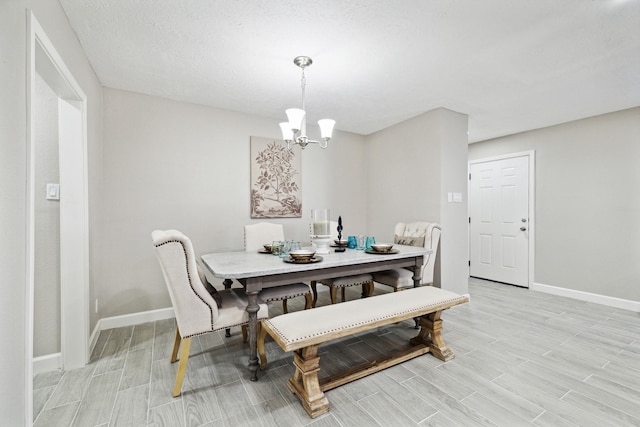 dining space with a textured ceiling and a notable chandelier