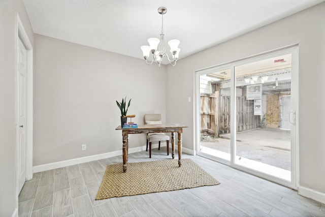 office space featuring light wood-type flooring and an inviting chandelier