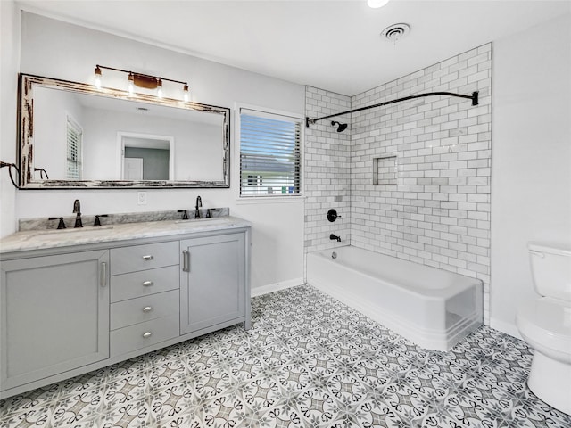 full bathroom featuring tiled shower / bath combo, toilet, tile patterned floors, and vanity