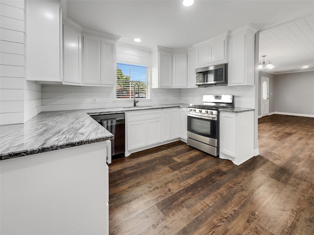 kitchen featuring white cabinetry, stainless steel appliances, dark stone countertops, sink, and dark hardwood / wood-style floors