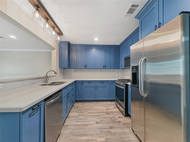 kitchen featuring light hardwood / wood-style flooring, stainless steel appliances, tasteful backsplash, blue cabinets, and sink