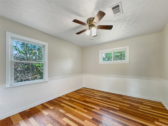 unfurnished room with plenty of natural light, ceiling fan, and wood-type flooring