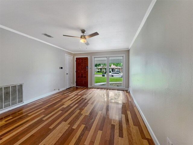 empty room with crown molding, ceiling fan, and hardwood / wood-style floors