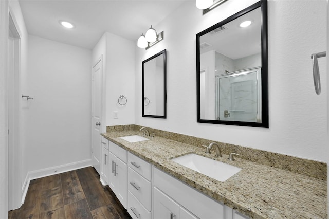 bathroom featuring hardwood / wood-style floors, vanity, and a shower with shower door