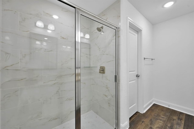 bathroom featuring a shower with door and wood-type flooring