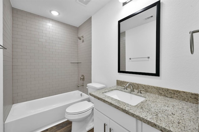 full bathroom featuring toilet, vanity, wood-type flooring, and tiled shower / bath