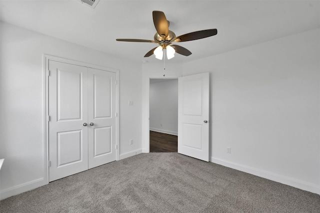 unfurnished bedroom featuring ceiling fan, dark carpet, and a closet