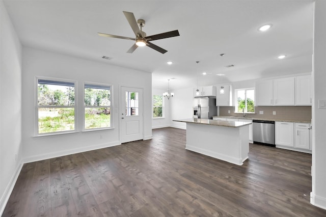 kitchen featuring appliances with stainless steel finishes, white cabinetry, a wealth of natural light, and a kitchen island