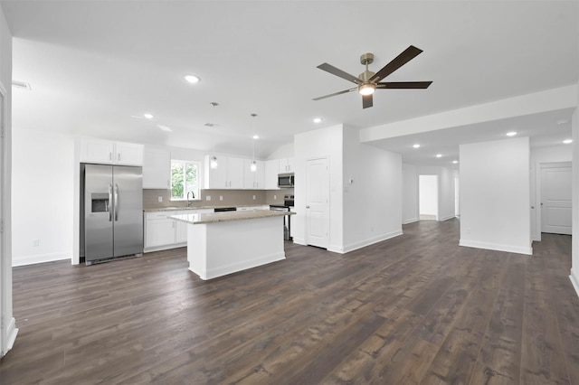 kitchen featuring dark wood-type flooring, ceiling fan, appliances with stainless steel finishes, a kitchen island, and white cabinetry