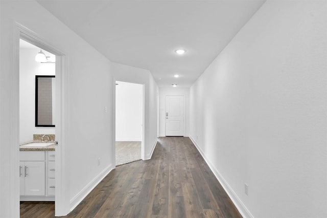 corridor with sink and dark wood-type flooring