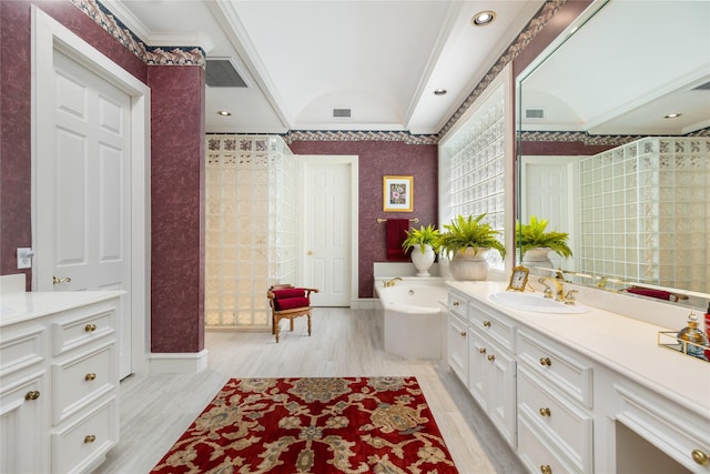 bathroom featuring a bathing tub, vanity, hardwood / wood-style flooring, and ornamental molding