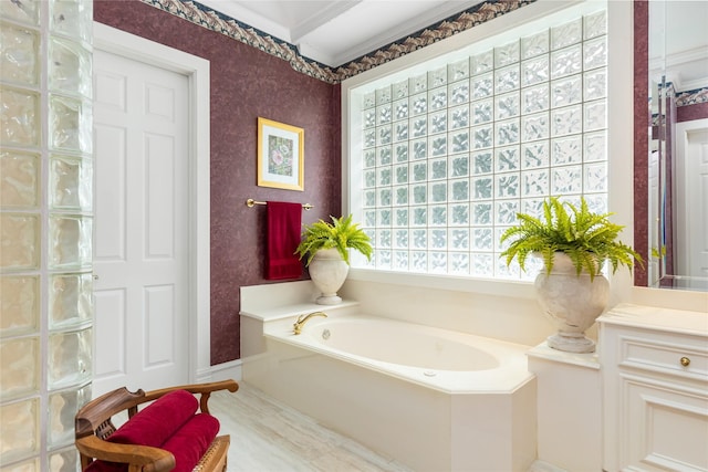 bathroom with a bathtub, vanity, and ornamental molding