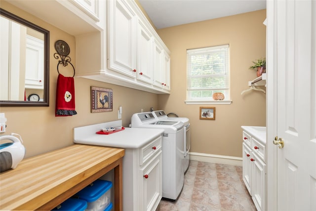 clothes washing area featuring cabinets, light tile patterned flooring, and washing machine and clothes dryer