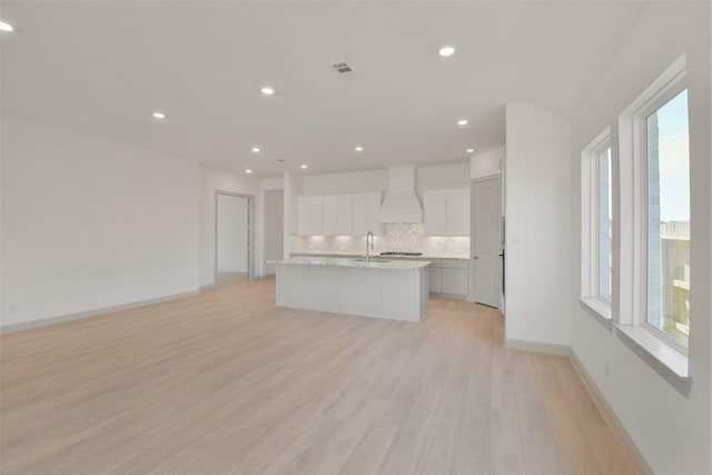13318 Pine Lake Bnd, Tomball, TX 77375 - unfurnished living room featuring a healthy amount of sunlight, light hardwood / wood-style floors, and sink