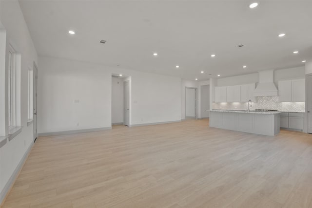 13318 Pine Lake Bnd, Tomball, TX 77375 - unfurnished living room featuring light hardwood / wood-style flooring and sink
