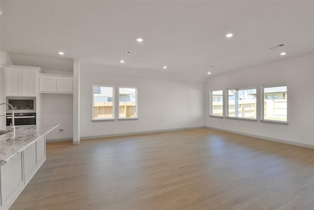 13318 Pine Lake Bnd, Tomball, TX 77375 - unfurnished living room featuring light hardwood / wood-style floors and plenty of natural light