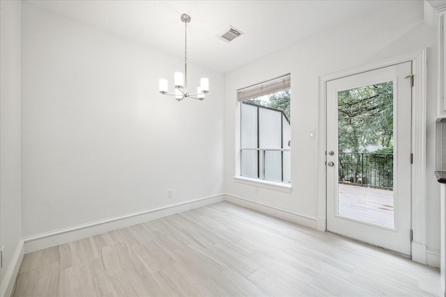 unfurnished dining area featuring a chandelier