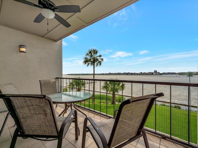 balcony with a rural view, a water view, and ceiling fan