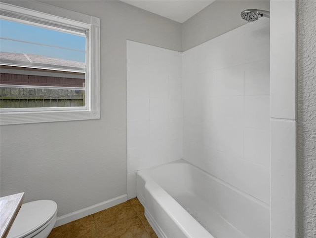 bathroom featuring toilet, tile patterned flooring, and shower / washtub combination