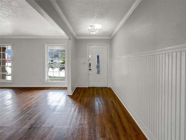 foyer entrance featuring dark hardwood / wood-style flooring, a textured ceiling, and ornamental molding