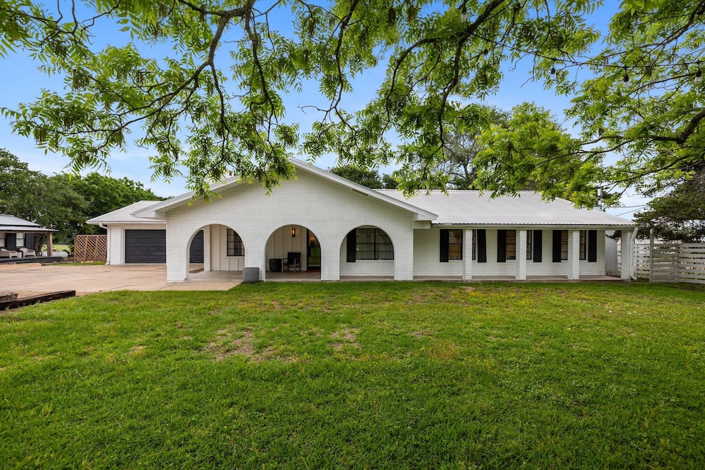 back of house featuring a garage and a lawn