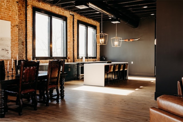 dining room featuring hardwood / wood-style flooring and brick wall