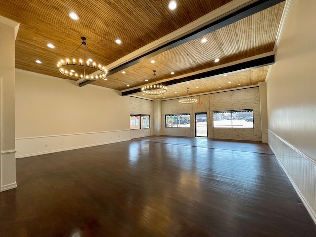 empty room featuring dark hardwood / wood-style floors, a notable chandelier, ornamental molding, and wood ceiling