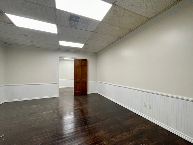 unfurnished room featuring dark hardwood / wood-style floors and a drop ceiling