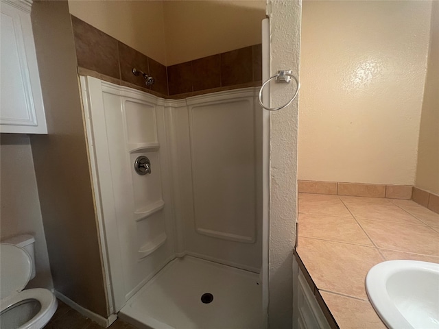 bathroom featuring walk in shower, sink, and toilet