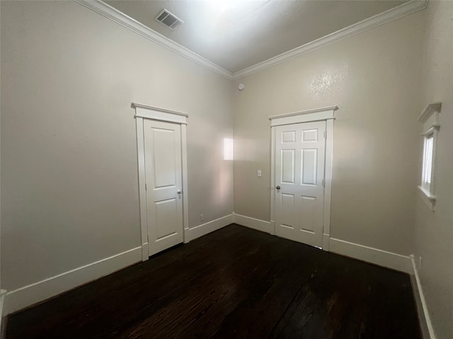 empty room featuring crown molding and dark wood-type flooring