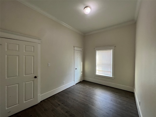 spare room featuring ornamental molding and dark hardwood / wood-style floors