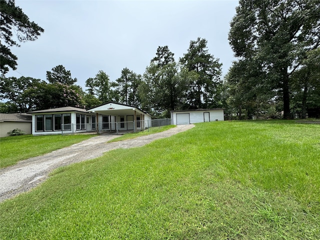 view of front of house with an outbuilding, a front lawn, and a garage