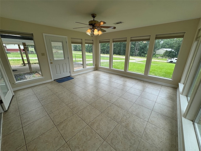 unfurnished sunroom with ceiling fan and a healthy amount of sunlight