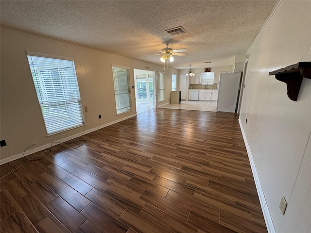 unfurnished living room featuring ceiling fan and a textured ceiling