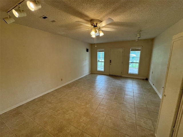 spare room with light tile patterned floors, a textured ceiling, and ceiling fan