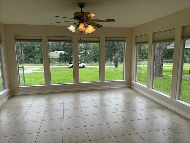 unfurnished sunroom featuring ceiling fan