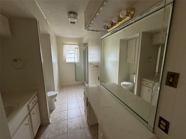 bathroom with a textured ceiling, vanity, toilet, and a shower with door