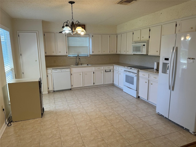 kitchen with white appliances, sink, hanging light fixtures, a notable chandelier, and white cabinetry