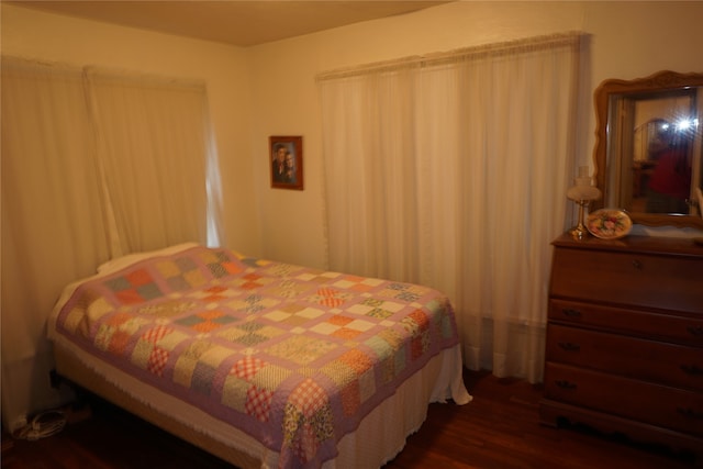 bedroom with dark hardwood / wood-style flooring