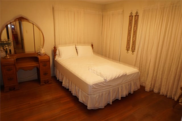 bedroom with dark wood-type flooring