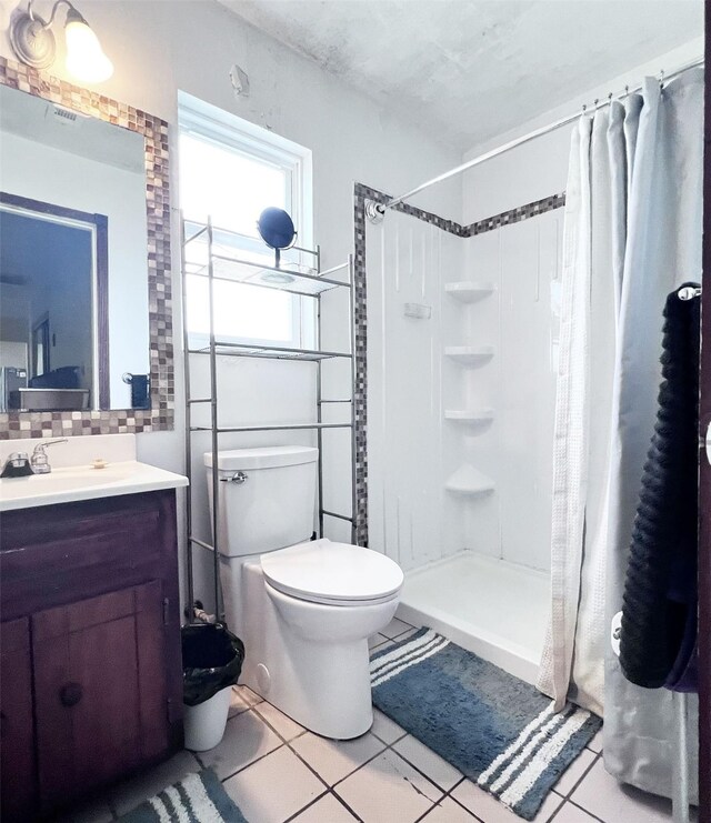 13074 Clover Ln, Iola, TX 77861 - bathroom featuring a shower with shower curtain, decorative backsplash, tile patterned flooring, and toilet