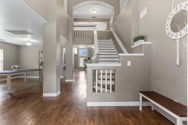 stairs featuring wood-type flooring and a high ceiling