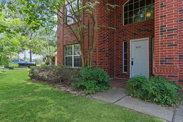 entrance to property featuring a lawn