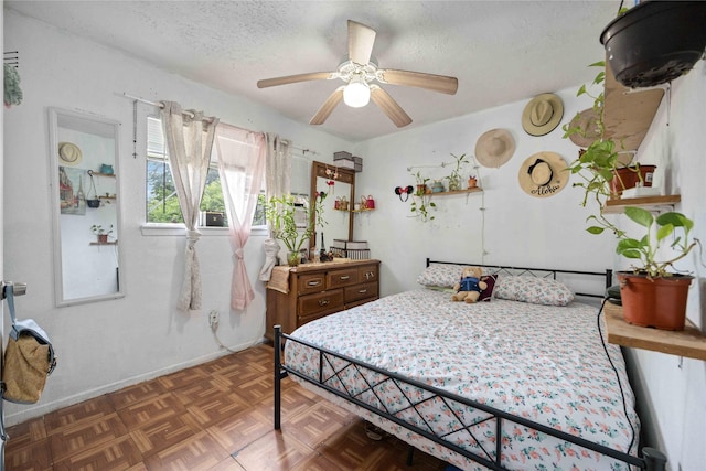 bedroom featuring dark parquet flooring, a textured ceiling, and ceiling fan