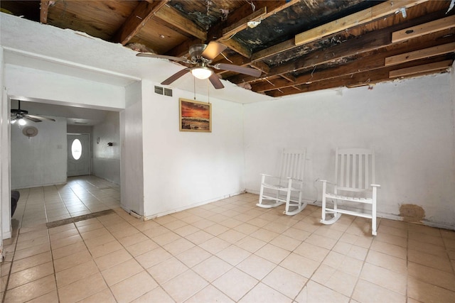 tiled empty room featuring ceiling fan